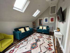 TillinghamLime Tree Cottage的客厅配有2张蓝色的沙发和地毯。
