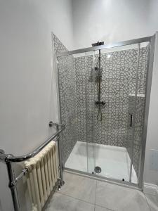 TillinghamLime Tree Cottage的浴室里设有玻璃门淋浴