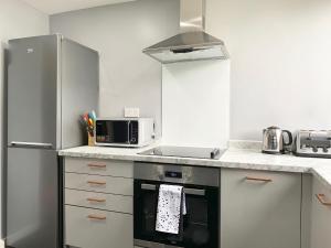 东基尔布赖德Pentland House - Lovely 2 bed flat in East Kilbride的厨房配有炉灶和微波炉。