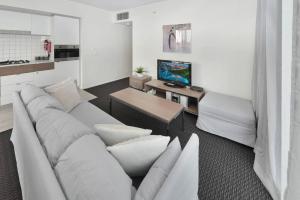 阿德莱德Light & Airy 3 Bd CBD Apt: BalconyTramWifi/Parking的客厅配有白色沙发和电视