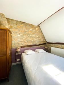 沙托纳城堡酒店的一间卧室设有一张大床和石墙