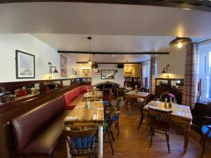 安布尔Harbour Inn的一间带桌椅的餐厅和一间酒吧