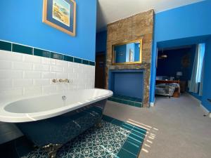 安布尔Harbour Inn的浴室设有白色浴缸和蓝色的墙壁。