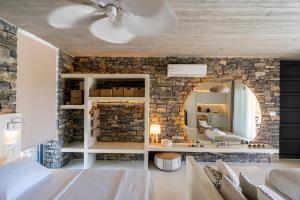 帕琉乔拉Akra Grammeno Beachfront Villas的一间卧室设有石墙和镜子