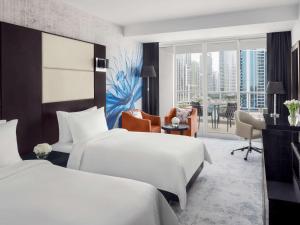 迪拜迪拜朱美拉湖塔楼瑞享酒店的酒店客房配有两张床和一张书桌