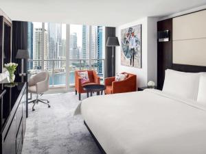 迪拜迪拜朱美拉湖塔楼瑞享酒店的酒店客房,配有一张床、一张桌子和椅子
