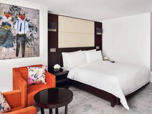 迪拜迪拜朱美拉湖塔楼瑞享酒店的配有一张床和一把椅子的酒店客房