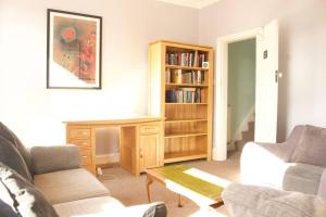 曼彻斯特Suite 1 - Cosy Room Close to MCR City Centre的带沙发和书架的客厅