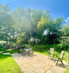 HardhamTree Tops Holiday Let & Sauna South Downs West Sussex Sleeps 10的花园内带桌椅的庭院