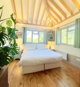 HardhamTree Tops Holiday Let & Sauna South Downs West Sussex Sleeps 10的卧室配有一张白色大床