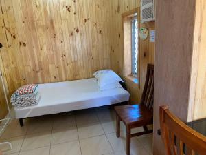 凯恩斯凯恩斯快乐旅游旅馆的小房间设有床和木墙