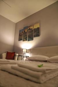 罗马Cavour Home的一间卧室配有两张床,墙上挂有绘画作品