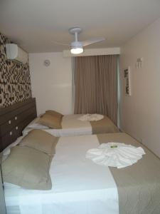 阿拉亚尔-杜卡布Resort em Arraial do Cabo, Momentos inesquecíveis em um apartamento de luxo com 2 quartos, 2 BANHEIROS e 2 vagas de carro entre a praia e a lagoa的一间卧室配有两张床和吊扇