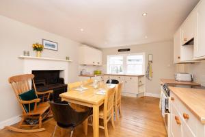 Stenton2 bed Haywood Cottage with garden的厨房以及带木桌和椅子的用餐室。
