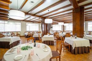 米兰达德埃布罗图丹卡米兰达酒店的餐厅设有白色的桌椅和窗户。