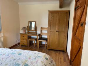 赛伦塞斯特Tupenny Cottage, Old Mill Farm, Cotswold Water Park的一间卧室配有一张床和一张带镜子的书桌