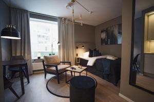 林雪平Sky Hotel City Apartments的一间卧室配有一张床、一张桌子和一张桌子