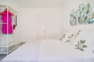 马拉加Villa Rosita Suites en Playa de la Malagueta con terraza的白色卧室配有白色的床和架子