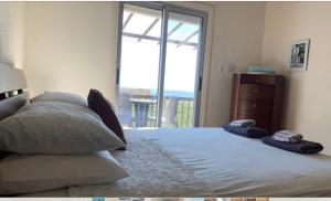 帕福斯Sunset Views Paphos的一间卧室配有带两个枕头的床和窗户