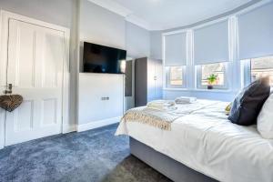 威萧Kali Apartment - Spacious 3 bed apartment in Wishaw的一间卧室设有一张床、电视和窗户