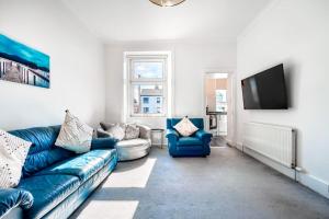 威萧Kali Apartment - Spacious 3 bed apartment in Wishaw的客厅配有蓝色的沙发和电视