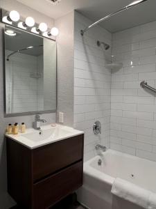 德尔雷比奇多弗度假村的一间带水槽、浴缸和镜子的浴室