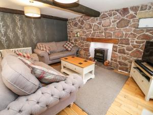阿贝尔格莱Dove Cottage的带沙发和壁炉的客厅
