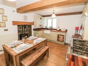 阿贝尔格莱Dove Cottage的一间带木桌的厨房和一间餐厅