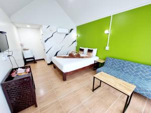 素可泰The Nature Sukhothai的一间卧室设有一张床和绿色的墙壁