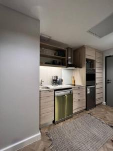 开普敦715 Foreshore Place Luxury Apartment-Cape Town CBD的厨房配有白色橱柜和绿色洗碗机。