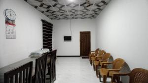 阿努拉德普勒Serene Homestay的墙上有一排椅子和钟的房间