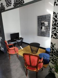 特镇Gîte et Chambres d'hôte L'Amarante的客厅配有两把椅子和一张桌子