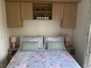 米勒姆Lili-anns Retreat Cosy Holiday Home的一间卧室,床上有粉红色的鲜花