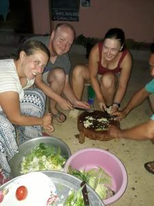NongkhiawLamorn Guesthouse的一群人坐在桌子旁吃着食物