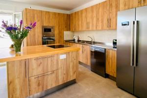 托雷加迪亚罗Villa La Roca的厨房配有木制橱柜和不锈钢冰箱。