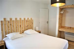 Romagnat5 mn Zenith Grande Halle Auvergne,pied de Gergovie,Garage,Netflix的卧室配有白色的床和木制床头板
