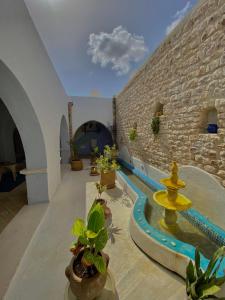 米多恩Hôtel Djerba Authentique - Au centre de Midoun的一座别墅,设有游泳池和砖墙