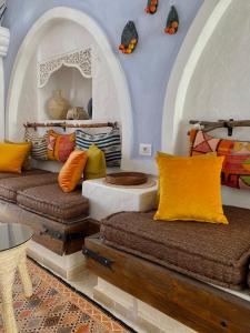 米多恩Hôtel Djerba Authentique - Au centre de Midoun的配有色彩缤纷的枕头的客房内的两张床