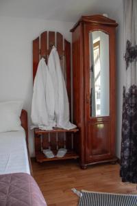 Căpăţîneni-UngureniPensiunea Ricky的一间卧室配有床和白色床单的橱柜