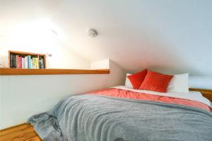 波特兰Private Studio, Lofted Bed, Soaking Tub & Patio的一间卧室配有一张带两个红色枕头的床