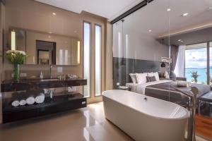 攀瓦海滩X10 Seaview Suites at Panwa Beach的一间带浴缸和床的浴室以及一间卧室