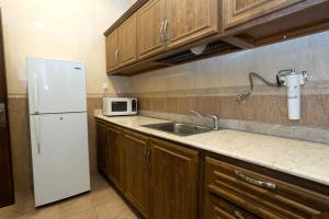 科威特Relax inn Apartment - Fahaheel的厨房配有白色冰箱和水槽