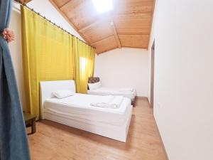 济州市济州吉琳住宿加早餐旅馆的一间设有两张床和黄色窗帘的房间