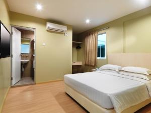 马六甲菲尼西客栈酒店的一间带大床的卧室和一间浴室