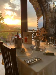 ŠirokaIl Tramonto的一张桌子,上面放着一杯葡萄酒,并享有海景