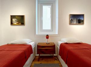 里斯本New Art Apartment的一间卧室设有两张床和窗户。