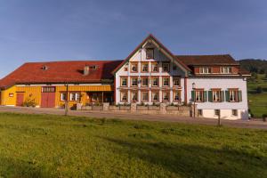 阿彭策尔Landgasthaus Neues Bild, Eggerstanden的前面有田野的大建筑