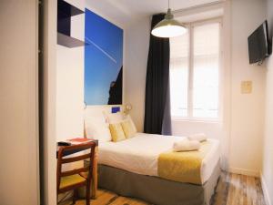 里昂辛普龙酒店的一间小卧室,配有床和窗户