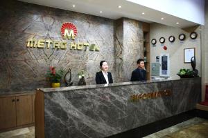 平泽市Metro Pol Tourist Hotel的两人站在地铁酒店的前台
