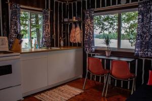 OmpahCedar Cabin - North Frontenac Lodge的厨房配有桌子和两把椅子以及窗户。